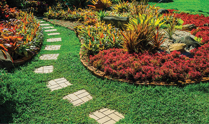 Garden landscape design with pathway intersecting bright green lawns and shrubs white sheet walkway in the garden. Landscape design with colorful shrubs. grass with bricks pathways. lawn care service.