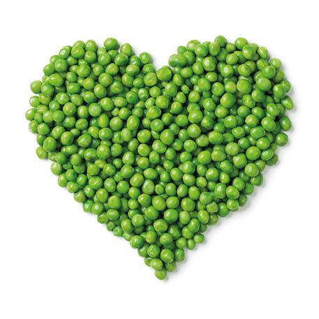 Fresh green peas in heart shape isolated on white background 