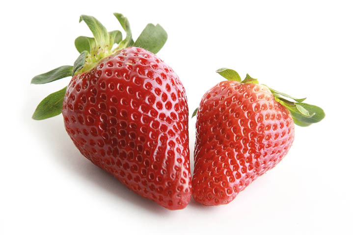 The two strawberries on a white surface