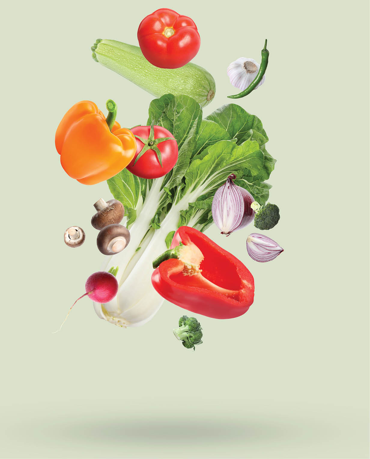 Many different fresh vegetables falling on beige background