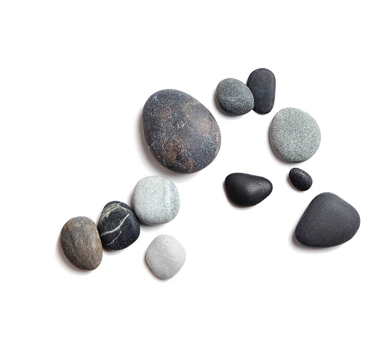 Scattered sea pebbles. Smooth gray and black stones isolated on white background. Top view