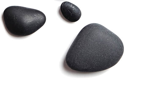 Scattered sea pebbles. Smooth gray and black stones isolated on white background. Top view