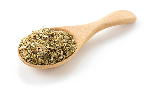 oregano on wood spoon on white