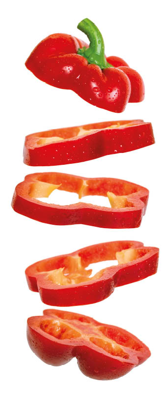 Creative concept with flying red paprika. Sliced floating pepper. Levity capsicum vegetable isolated on white background
