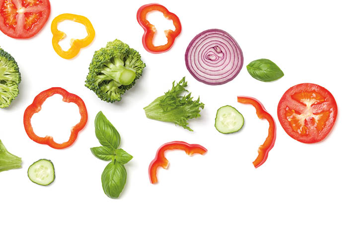 Creative layout made of tomato slice, onion, cucumber, basil leaves. Flat lay. Food concept. Vegetables isolated on white background.