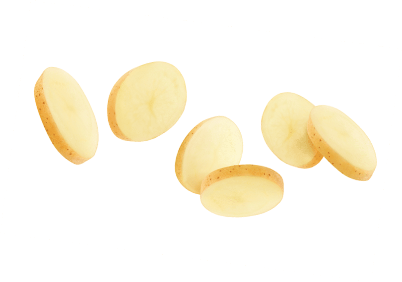 Isolated potato pieces in the air. Unpeeled slices of raw washed potato falling down over white background